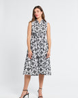 Woman wearing a black and white midi floral dress on a white background