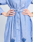 Blue dress with floral patterns with tie on a plain background