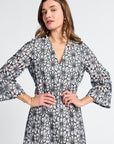 Woman wearing a black and white floral caftan on a white background