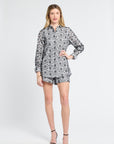 Woman wearing a black and white floral blouse on a white background