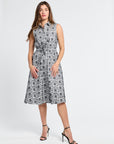 Woman wearing a sleeveless black and white floral dress on a white background