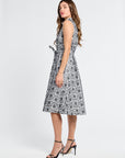 Woman wearing a black and white floral mid-length dress on a white background