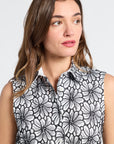Woman wearing a sleeveless dress with black floral pattern on a white background