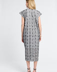 Woman modeling a black and white floral dress on a white background