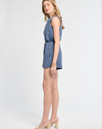 Woman modeling a denim blue blouse and shorts on a white background