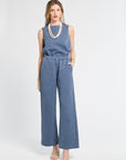 Woman wearing a blue blouse and pants on a white background