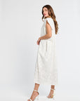 Woman wearing a white caftan and white heels on a white background