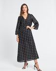 Woman wearing a sheer black caftan with white flowers on a white background