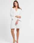 Woman wearing a v-neck white lace dress on a white background