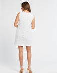 Woman modeling a white sleeveless mini dress on a plain background