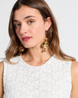 Woman modeling a white dress with detailing against a white background