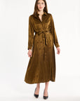 A woman modeling the Golden Umber Eleanor Shirt Dress belted at the waist with black heels, full-length front view, photographed against a plain white studio background.
