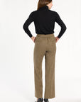 A woman modeling the Painter's Fleck Herringbone Ellis Pants with a black turtleneck and heels, back view, photographed against a plain white studio background.
