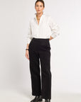 Person wearing a white shirt and black pants on a white background
