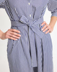 A close-up shot of the navy striped shirt dress with the matching sash tied in a bow around the model's waist.