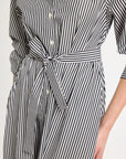 A detail shot of the sash tied in a knot around the waist of the striped shirt dress.