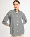 A woman modeling a striped button-up shirt in a vertical pattern, with the shirt collar visible and buttons done up to the top.