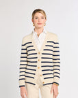 Woman wearing a striped cardigan over a white shirt on a plain background