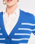 Person wearing a blue cardigan with white stripes over a white shirt on a light gray background