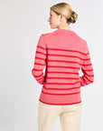 Woman wearing a pink striped sweater on a white background