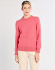 Woman with pink sweater on with white background.