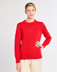 Woman wearing a red sweater on a light gray background