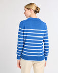 Woman wearing a blue and light blue striped sweater on a light gray background