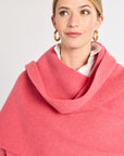 Woman wearing a pink scarf against a plain background