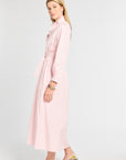 Woman wearing a light pink dress with a white background