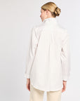 Woman wearing a white shirt and beige pants on a white background