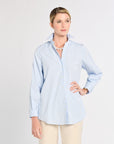 Woman wearing a light blue striped shirt and beige pants on a white background