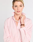 Woman wearing a pink striped shirt with a white background
