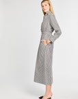 Woman wearing a black and white striped dress on a white background