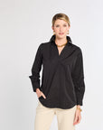 Woman wearing a black shirt and beige pants on a white background