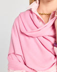Person wearing a pink scarf with a plain background