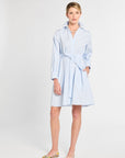 Woman wearing a light blue dress with a white background