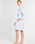 Woman wearing a light blue dress with a white background