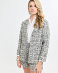 Woman wearing a tweed blazer and shorts set on a white background