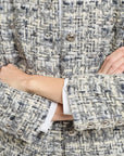 Close-up of a person wearing a patterned coat with button details.