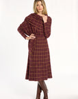 woman wearing a plaid skirt and wrap set with tall croc boots on a white background