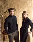 Man wearing a black cashmere quarter zip with woman next to him in a black cashmere cardigan