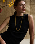 Woman modeling a cashmere shell with a gold necklace