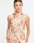 Woman wearing a sleeveless patterned dress on a white background