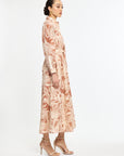 Woman wearing a long, patterned dress on a white background