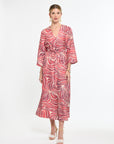 Woman wearing a red and white patterned dress on a white background