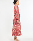 Woman wearing a red patterned dress on a white background