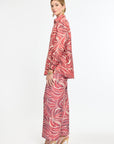 Woman wearing a red and white patterned outfit on a white background