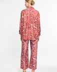 Woman wearing a red and white patterned outfit on a white background