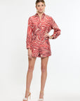 Woman wearing a red and white patterned shorts and shirt on a white background
