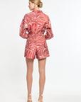 Woman wearing a red and white patterned shorts and shirt on a white background
